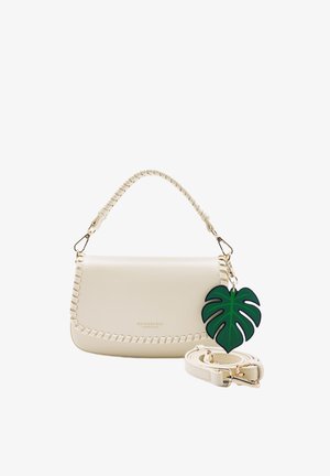 Cream handbag with braided edges and top handle, a detachable strap, and a green leaf-shaped keychain attached to the handle.