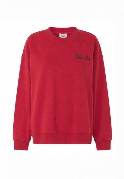 Sweat-shirt rouge à col rond avec manches longues et petit texte noir "BAUM UND PFERDGARTEN" sur le haut gauche de la poitrine.