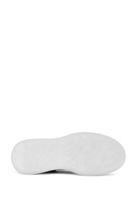 Scarpa con una suola esterna in gomma bianca solida, caratterizzata da una superficie testurizzata e una forma arrotondata, progettata per comfort e stabilità.