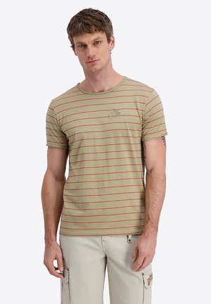 Man wearing beige t-shirt with thin red horizontal stripes and light-colored cargo pants, standing against plain white background.