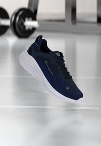 Marineblaue Laufschuhe mit strukturiertem Obermaterial, gepolstertem weißen Sohle und schwarzen Akzenten. Verfügt über Schnürsenkel und das "Champion"-Logo an der Seite.