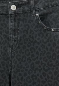 Črne denim hlače z rahlo embosiranim leopardjim potiskom, s srebrnim okovjem in zakovicami blizu žepa.