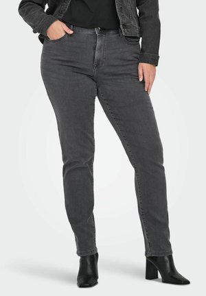 Sive jeans iz denima s slim krojem, z sprednjimi žepi, visokim pasom in subtilnim bledenjem. Ujemajoče se z črnimi čevlji s peto do gležnja.