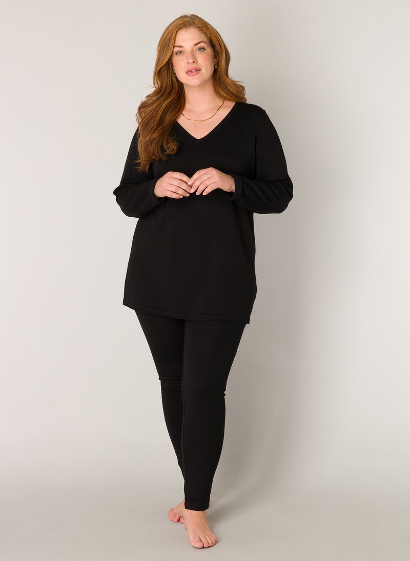 Zwarte lange mouwen V-hals tuniek in combinatie met bijpassende zwarte leggings, voorzien van een relaxte pasvorm en zachte stof, ideaal voor casual gebruik.