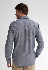 Camicia da uomo a maniche lunghe in tessuto a righe navy e bianche. Presenta un colletto e polsini con bottoni, con una vestibilità comoda e una piega sulla schiena.