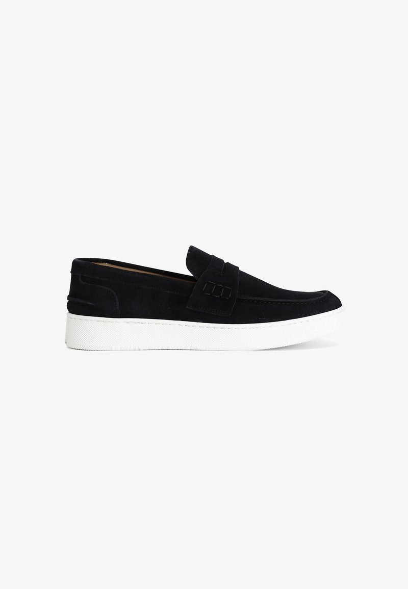 Mocassino in camoscio nero con suola in gomma bianca e ampia fascia decorativa sulla parte superiore, mostrato di profilo su sfondo bianco.