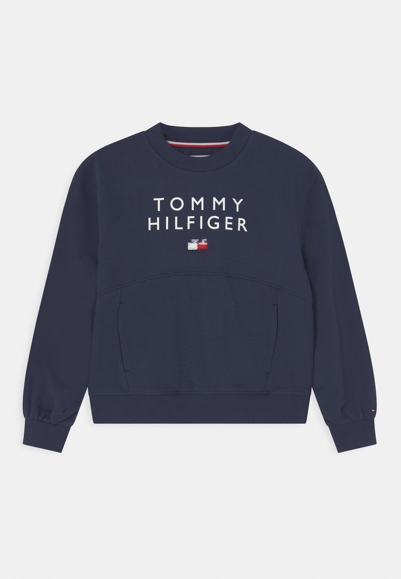 Sweat-shirt bleu marine à col rond, manches longues et poignets côtelés. Présente le logo "TOMMY HILFIGER" et un petit emblème de drapeau sur la poitrine.