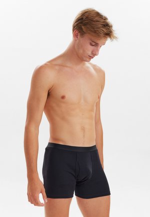 Sorte bomuldsboxershorts med en tætsiddende pasform, elastisk talje og en glat tekstur. Ingen mønstre eller yderligere accenter til stede.