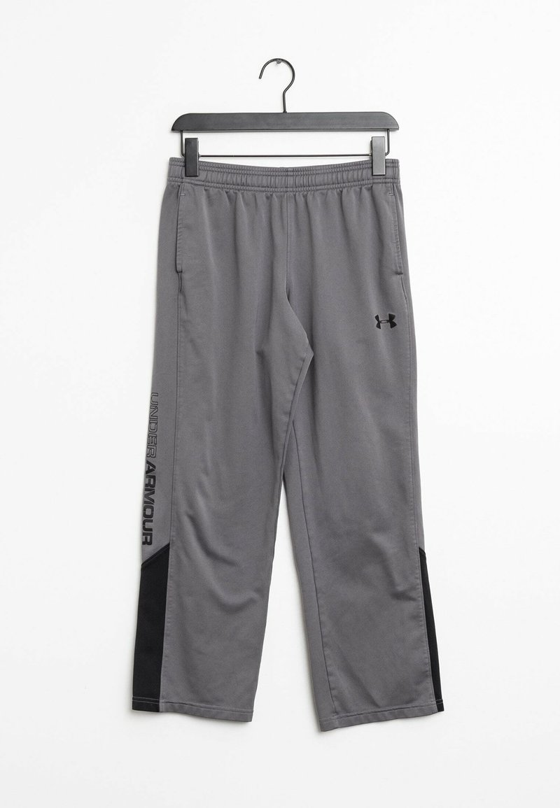 Szare spodnie sportowe z elastycznym pasem, bocznymi kieszeniami i czarnymi akcentami. Wyposażone w logo "UNDER ARMOUR" wzdłuż nogawki. Gładka faktura.