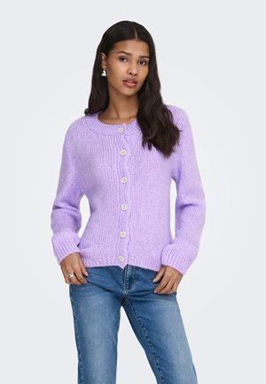 Lilla strikket cardigan med rund hals, ribbet tekstur og store knapper, kombinert med blå jeans. Inkluderer lange ermer og en avslappet passform.