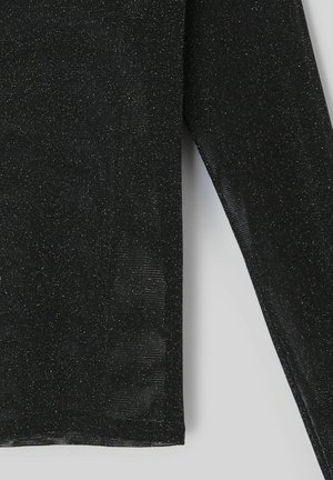 Haut noir à manches longues avec une texture subtile de paillettes argentées, présenté devant un fond clair uni, montrant le détail des manches et du torse.