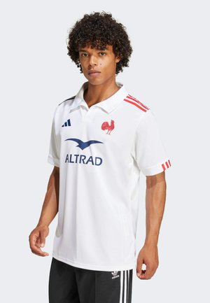 Hvid rugbytrøje med røde accenter og en coq-logo. Har krave, korte ærmer og sponsorskrift "ALTRAD" i blåt.