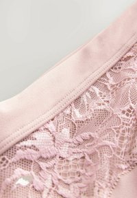 Lenjerie de culoare roz deschis, realizată dintr-un material moale, cu un band elastic neted și detalii intricate din dantelă florală pe margine, completată de un model texturat.