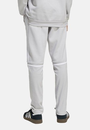 Lichtgrijze joggings met witte streepaccenten, met een relaxed fit en zacht materiaal. De zoom heeft ribgebreid trim voor extra comfort.