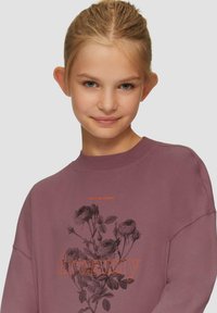 Lila Sweatshirt mit floralem Muster in Schwarz und dem Wort "dreamy" in Orange. Einfacher Rundhalsausschnitt und entspannter Schnitt.