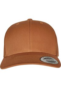Casquette snapback marron avec une forme structurée, texture en tissu et visière plate. Présente une étiquette ronde sur le côté avec des détails de marque.