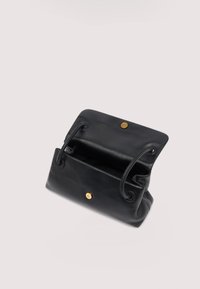 Bolso de mano de cuero negro con asas de cordón, solapa abierta y cierre magnético dorado sobre un fondo claro.