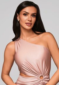 Top na jedno rameno v barvě pudru vyrobený z hladké látky, ozdobený kroucením a kulatým výřezem v pase. Jemný lesk.