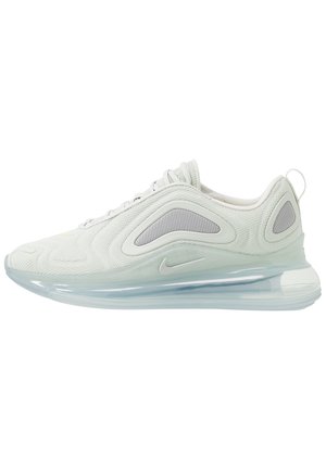 Białe i jasnoszare buty sportowe Nike z przezroczystą, amortyzowaną powietrzem podeszwą, panelami z siateczki i pętelką na pięcie, pokazane z zewnętrznej strony.