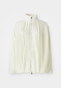 Giacca bianca plissè con colletto alto, chiusura anteriore con zip e orlo elastico. Realizzata in un tessuto leggero e lucido.