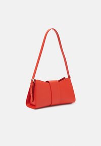 Sac à main en cuir rouge avec une forme structurée, agrémenté d'une large sangle centrale. Comprend une longue bandoulière réglable et une texture lisse.