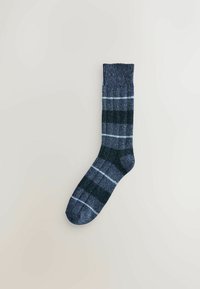 Tumed sinine sokk ribalehiga ja vahelduva tumeda ja heleda sinise ruudulise mustriga, millel on suletud varvas ja ääres keeratud osa.