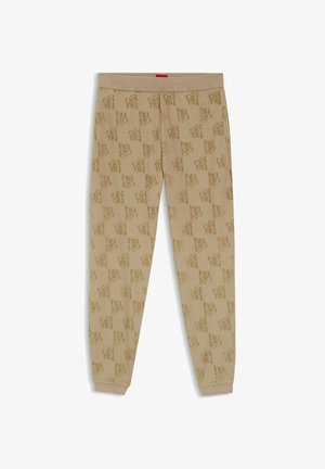 Pantaloni jogger beige con vita e polsini elasticizzati, caratterizzati da un motivo a rilievo con il logo "hugo" in ripetizione su tutto il tessuto.