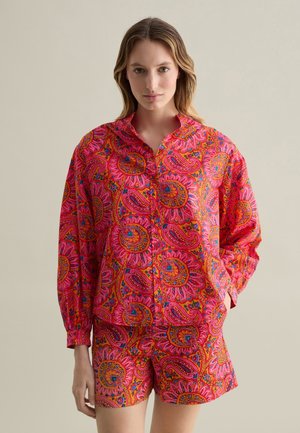 Camicia a maniche lunghe con colletto, in tessuto di cotone, caratterizzata da un vivace motivo paisley rosa, abbinata a pantaloni shorts coordinati. Tessuto in cotone con una texture morbida.