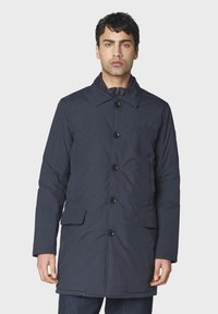 Dunkelblauer, gepolsterter Mantel mit kragenförmigem Ausschnitt, vorderem Knopfverschluss, zwei seitlichen Taschen und einer Brusttasche. Glatte Textur.