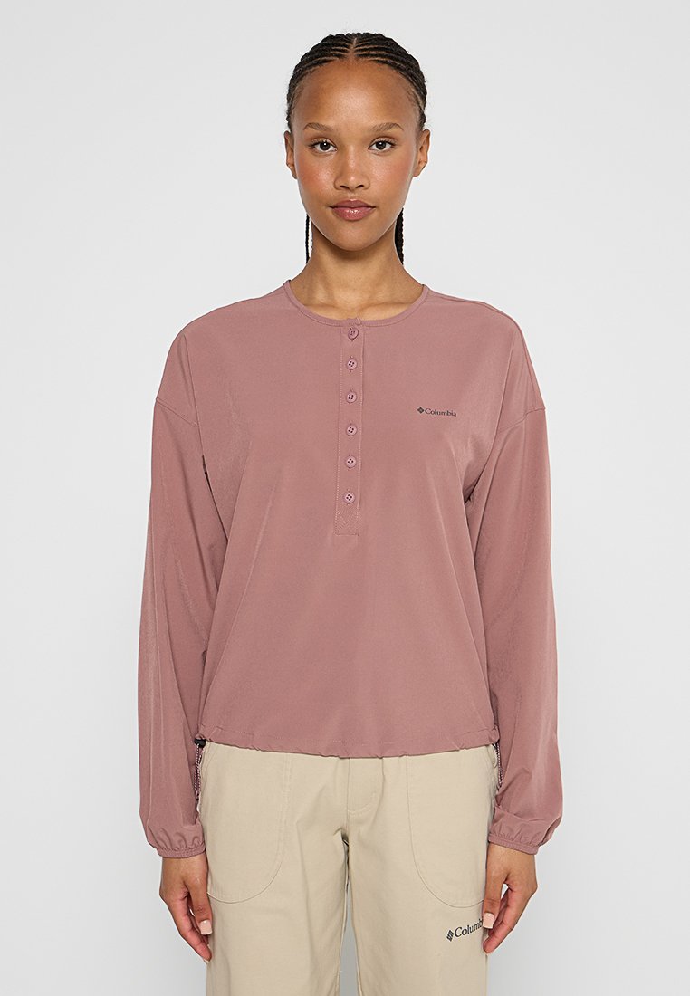 Koszula z długim rękawem w kolorze przybrudzonego różu, wykonana z lekkiego materiału. Posiada okrągły dekolt i dyskretną logo Columbia.