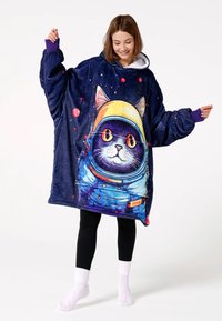 Zils pūkains oversized kapucis ar grafiku, kurā attēlots kaķis astronauta tērpā uz zvaigžņota fona. Violetas aproces un balta kapuce.