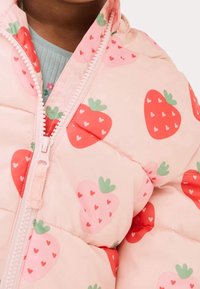 Roze pufferjack met aardbeienpatroon, voorzien van rode aardbeien en groene accenten, ritssluiting en gestikte textuur.