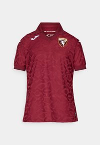 Crvena majica s suptilnim teksturiranim uzorkom, koja ima klasičnu kragnu i logo Torina FC na prsima. Kratki rukavi i prozračni materijal.