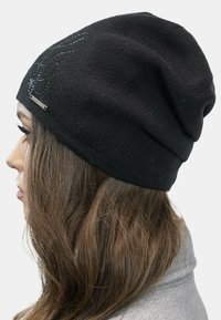 Berretto in maglia nera con una texture morbida e una vestibilità slouchy, caratterizzato da motivi decorativi in strass e un piccolo etichetta con il marchio sul lato.