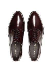 Chaussures habillées en cuir bordeaux avec une finition polie, dotées d'un laçage fermé, d'un bout rond et de coutures décoratives discrètes. Logo doré sur la semelle intérieure.