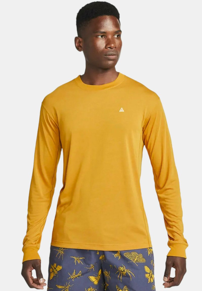 Long-sleeve shirt in bright yellow with a round neckline and a small white logo on the chest; smooth fabric, regular fit.