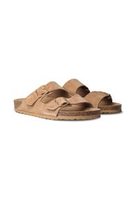 Sandales en suède beige avec deux sangles ajustables et une semelle en liège, dotées d'une semelle texturée pour la prise et le confort.