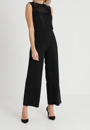 Zwarte jumpsuit met een transparante top met kralen en wijde pijpen, met een getextureerde afwerking en mouwloos ontwerp.