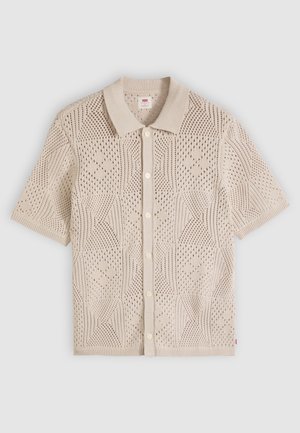 Bézs rövid ujjú kötött kardigán gombokkal az elején, texturált geometriai mintákkal, bordázott gallérral és mandzsettákkal.