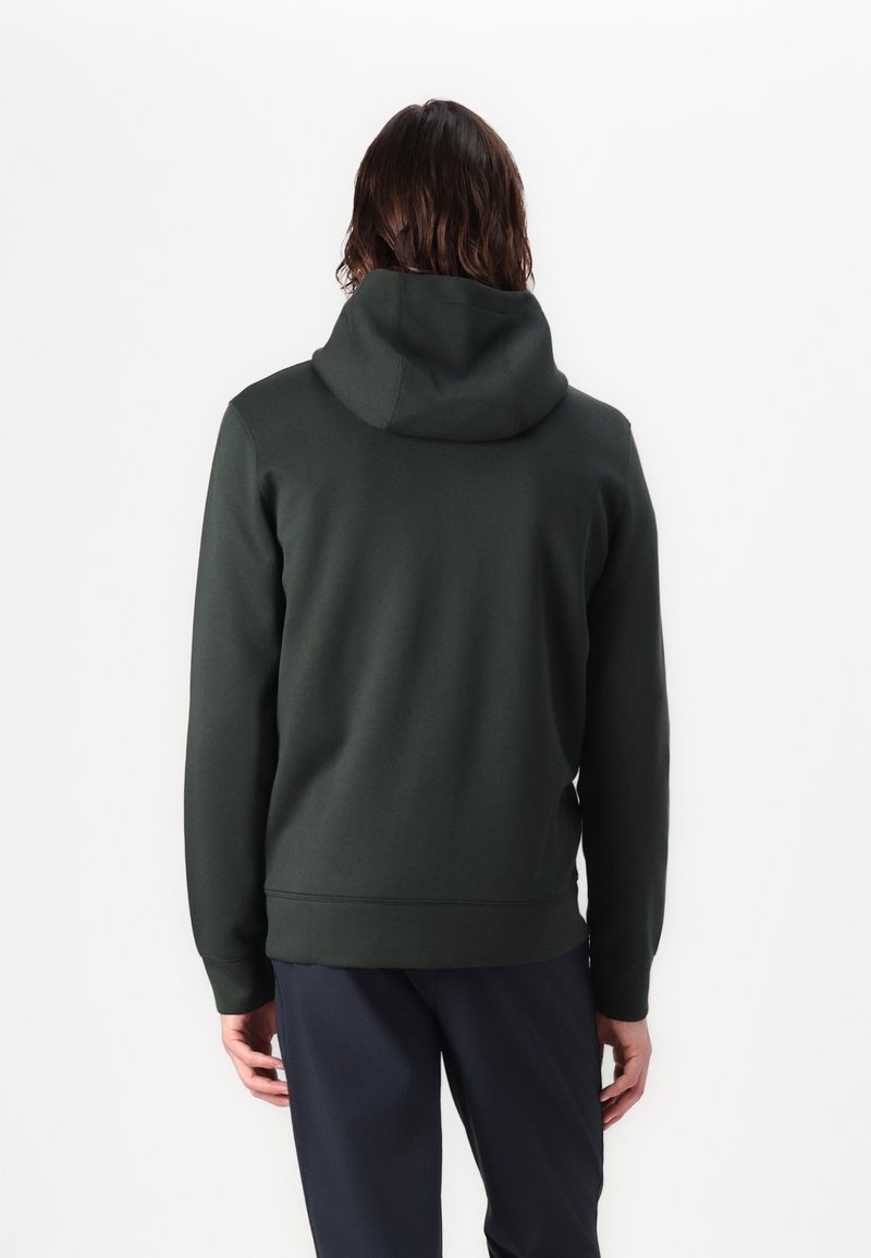Ciemnozielona bluza z kapturem o luźnym kroju, z dużym kapturem, prążkowanymi mankietami i prostym dołem. Gładka tekstura z minimalnymi detalami.