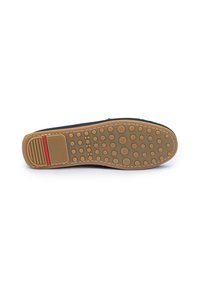 Semelle d'un mocassin marron avec des motifs circulaires antidérapants et une section de talon rectangulaire texturée comportant une bande rouge.