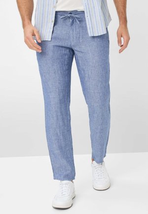Light blue linen trousers with an elastic waistband and drawstring. Features straight legs and a relaxed fit, paired with white sneakers.