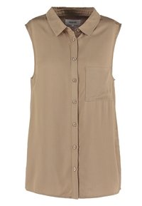 Chemise sans manches beige avec un col à rabat, une fermeture à boutons sur le devant et une poche poitrine unique. Fabriquée en tissu doux avec une texture lisse.