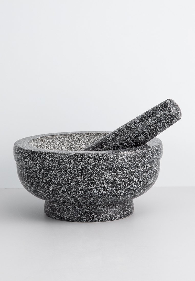Granite-Mörser und -Stößel-Set, dunkelgrau mit gesprenkelter Textur, abgerundetes Design, die Schüssel weitet sich sanft am Rand, der Stößel hat eine spitz zulaufende Enden.