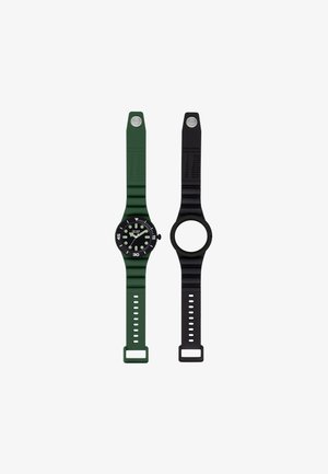 Deux montres-bracelets côte à côte, l'une avec un bracelet vert et un cadran noir affichant l'heure, l'autre avec un bracelet noir et un cadran vide.