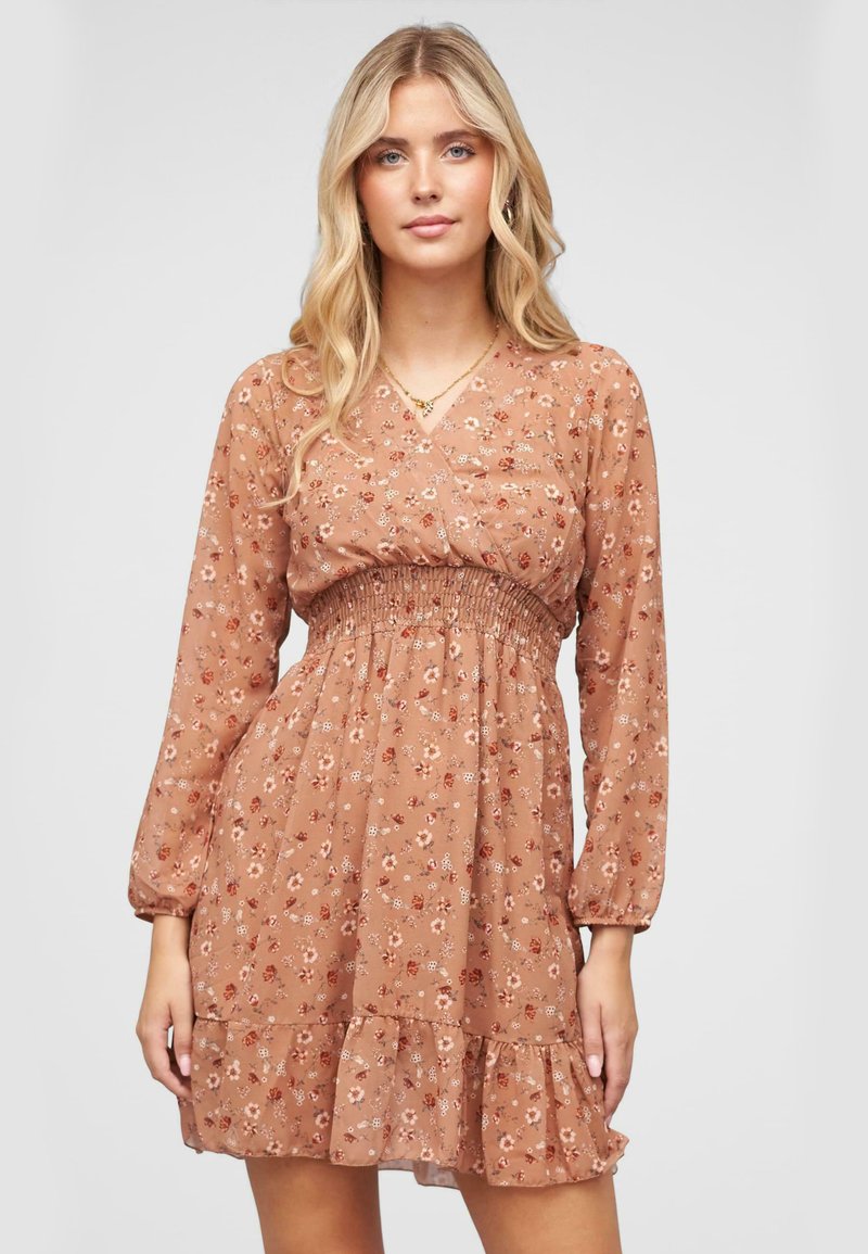 Robe fleurie marron avec des manches longues, un corsage froncé et un ourlet en volants. Fabriquée en tissu léger avec une texture douce.