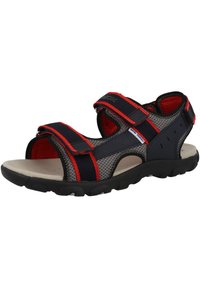 Sandali sportivi con fasce blu navy e rosse, design in rete, chiusure regolabili in Velcro, suola imbottita e suola in gomma nera testurizzata.