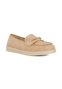 Beige suede loafer with stitched detailing and a small gold chain accent. Rounded toe and a light rubber sole, offering a casual look.