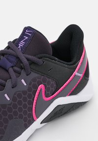 Tmav�ě fialová sportovní bota s hexagonálním vzorem, černými a růžovými akcenty, síťovinou, zpevněnou špičkou a bílou mezipodešví.