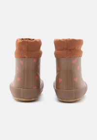 Brune gummistøvler med en polstret beige tekstilkrave, prydet med hjerte mønster i pink på skaftet og strukturerede gummisåler.